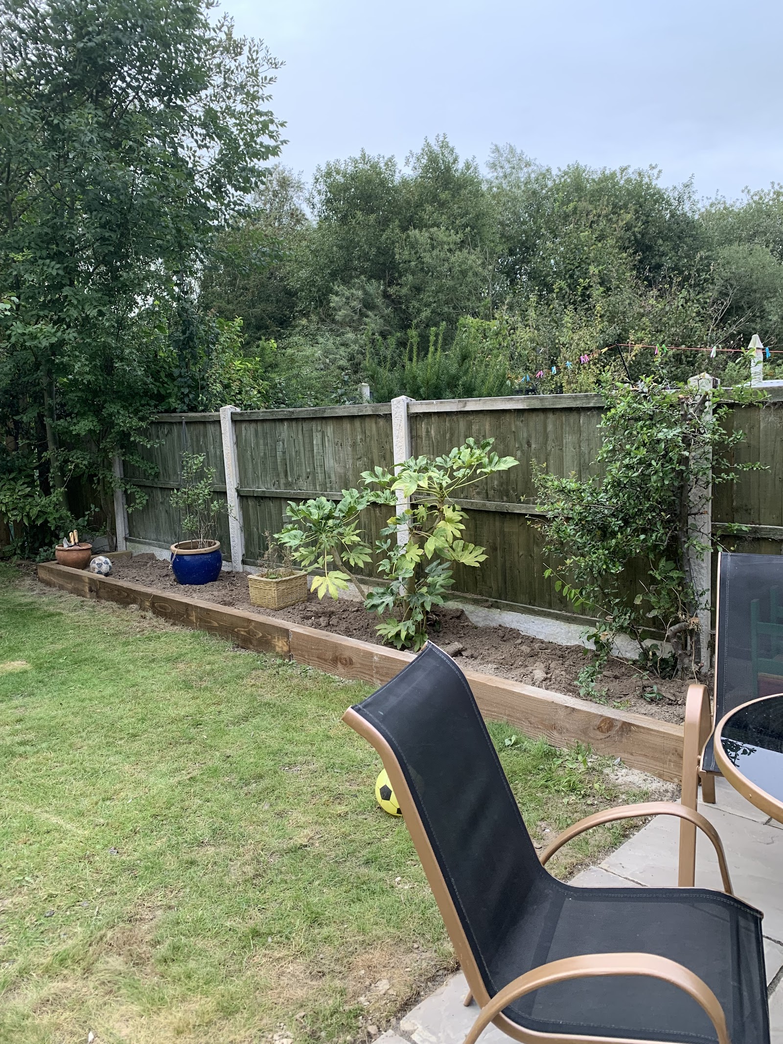 Reclaimed-sleeper raised bed and lawn with a paved seating corner