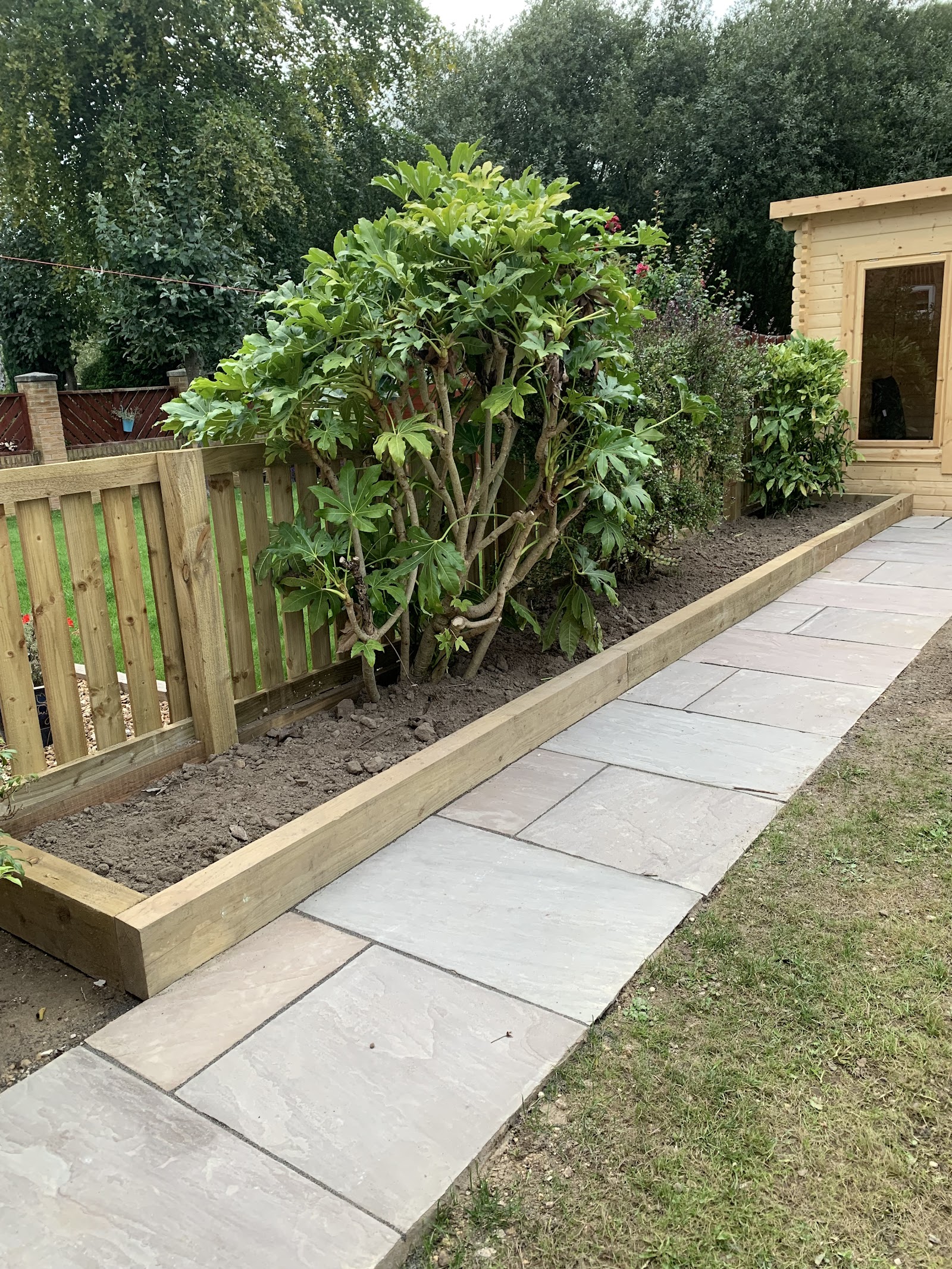Riven sandstone path laid through a planted bed by Lofthouse Garden Services